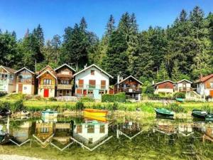 a group of houses next to a lake with boats at Le Cercle des Neiges Étoilé in Métabief