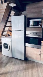 a kitchen with a refrigerator and a washing machine at Le Cercle des Neiges Étoilé in Métabief +12 photos