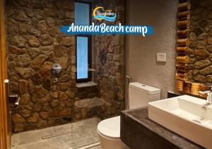 a bathroom with a toilet and a stone wall at Ananda Beach Camp in Nuweiba +145 photos