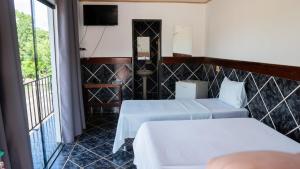 a hotel room with two beds and a balcony at Hotel Oasis 2 in Conceição do Araguaia