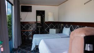 a hotel room with two beds and a television at Hotel Oasis 2 in Conceição do Araguaia