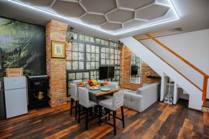 a dining room with a table and a couch at The Loft Esztergom - Központi privát ház, wellness in Esztergom