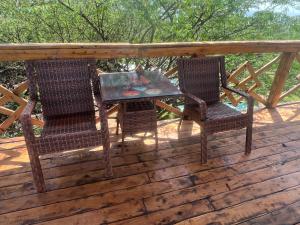 two chairs and a table on a deck at Arbaminch eco campsite and lodge in Ārba Minchʼ