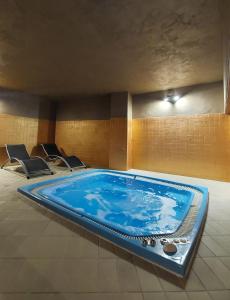 a swimming pool in a room with chairs around it at Hotel Cristallo in Sestriere