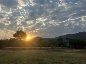 a sunset in a field with the sun in the sky at Arbaminch eco campsite and lodge in Ārba Minchʼ