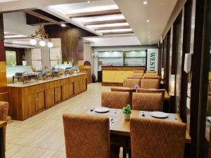 a dining room with tables and chairs and a restaurant at SK Premium Park GGN in Gurgaon