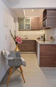 a kitchen with a chair and a vase with flowers at Galaris' Studio in Samos