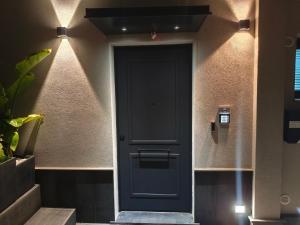 a dark blue door in a hallway with lights at Strettorooms in Villa San Giovanni