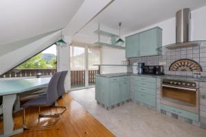 a kitchen with blue cabinets and a table with chairs at Rooms Hrominc in Bled