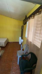a room with a bed and a chair and a phone at Accommodation in Copán Ruinas #6 in Copán Ruinas