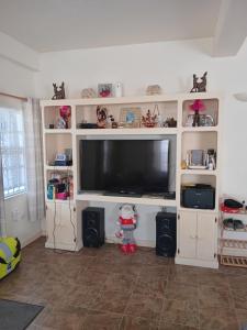 a living room with a large flat screen tv at Fijay Bay Inn in Carriacou