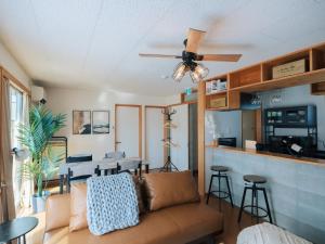 a living room with a couch and a ceiling fan at Aso Grand View in Aso