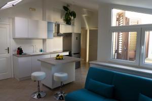a kitchen with a blue couch and a kitchen island at Nosside & Saffo Guesthouse in Amantea