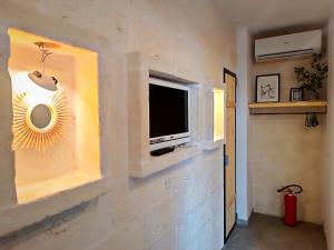 a living room with a tv on a wall at Minuetto 60 in Ostuni