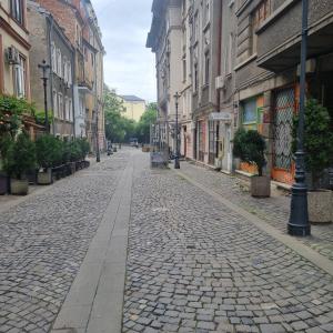 a cobblestone street in a city with buildings at Villa Boema- with parking for large business groups in Bucharest