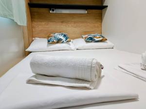 two beds with white towels and pillows on them at SAK Mobile Home Privlaka in Privlaka
