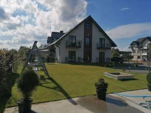 a large white house with a yard with plants at Rajska Zatoka Jantar in Jantar