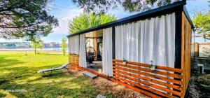 a small cabin with a window and a bench at SAK Mobile Home Privlaka in Privlaka