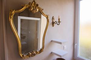 a gold mirror on a wall in a bathroom at Villa Hermès in La Flocellière +6 photos