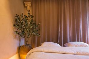 a bedroom with a bed and a vase with a plant at Villa Hermès in La Flocellière