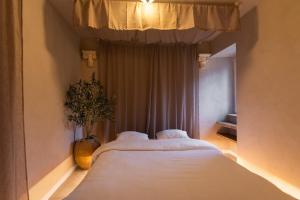 two beds in a bedroom with a vase with a plant at Villa Hermès in La Flocellière