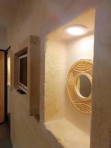 a room with a wall with a mirror and a tv at Minuetto 60 in Ostuni