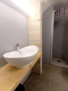 a bathroom with a white sink on a wooden counter at Minuetto 60 in Ostuni