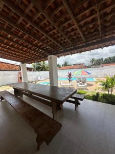 a wooden picnic table with a view of a pool at Pousada Caju - Barreirinhas - Lençóis Maranhenses - Hotel in Barreirinhas