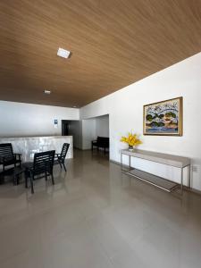 a lobby with a table and chairs and a painting at Pousada Caju - Barreirinhas - Lençóis Maranhenses - Hotel in Barreirinhas