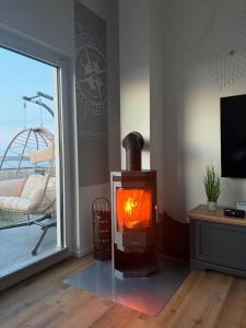 a wood stove in a room with a window at Strandvilla GLOWE - Strandjuwel in Glowe