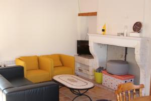 a living room with a couch and a fireplace at Au Charme Charentais Gite geel in Blanzaguet-Saint-Cybard-le-Peyrat