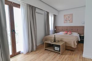 a bedroom with a bed and a table with flowers on it at Galaris' Luxury Room in Kokkari