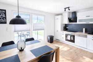 a kitchen and dining room with a table and chairs at Ferienhaus Seeoase - 70qm - Kamin -Terrassen - Parkplatz - Badestelle fußläufig in Joachimsthal