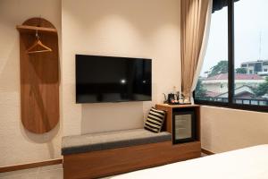 a living room with a large flat screen tv on the wall at Than Coffee & Homestay in Hai Phong