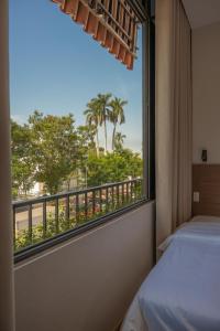 a bedroom with a window with a view of the beach at Than Coffee & Homestay in Hai Phong