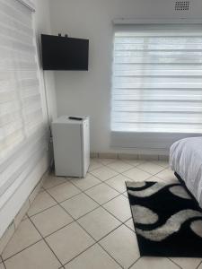 a bedroom with a bed and a window and a rug at Eagle Empire in Vereeniging
