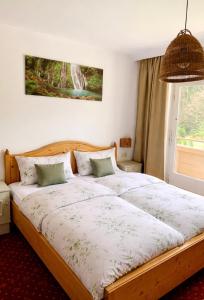 a bedroom with a large bed with a large window at Frühstückspension Waldeck in Mayrhofen