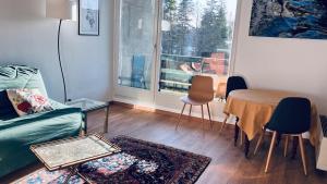 a living room with a couch and a table and a window at Le Reflet du Lac in Malbuisson