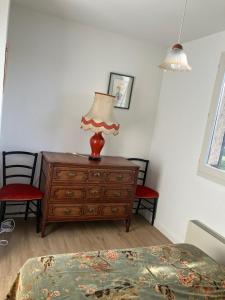 a bedroom with a dresser with a lamp on it at Le Reflet du Lac in Malbuisson