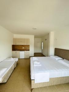 two beds in a large room with white walls at Apartmani ,,Del Mar'' in Ulcinj