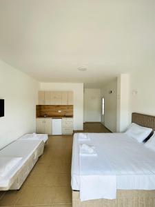 two beds in a room with white walls at Apartmani ,,Del Mar'' in Ulcinj