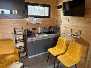 a kitchen with two yellow chairs in a tiny house at The Little House in Sohodol