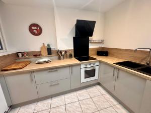 a kitchen with white cabinets and a counter top at L'entre 2 places, Apt 42 m² hyper centre Arras in Arras +5 photos