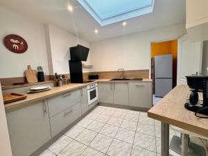 a large kitchen with white cabinets and a skylight at L'entre 2 places, Apt 42 m² hyper centre Arras in Arras
