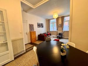 a living room with a black table and a couch at L'entre 2 places, Apt 42 m² hyper centre Arras in Arras