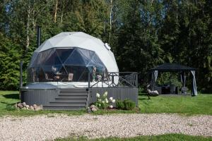 a yurt with a porch and stairs in a yard at Līgo glamping in Stacija Meitene