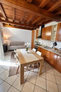 a kitchen and dining room with a wooden table at Casa Renoir appartamento a due passi dal lago in Verbania