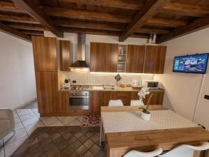 a kitchen with wooden cabinets and a table at Casa Renoir appartamento a due passi dal lago in Verbania