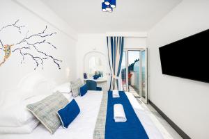 un soggiorno con divano e TV di Positano Art Hotel Pasitea a Positano
