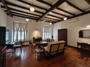 a living room with a piano and tables and chairs at Ezekiel House Residence in Cochin